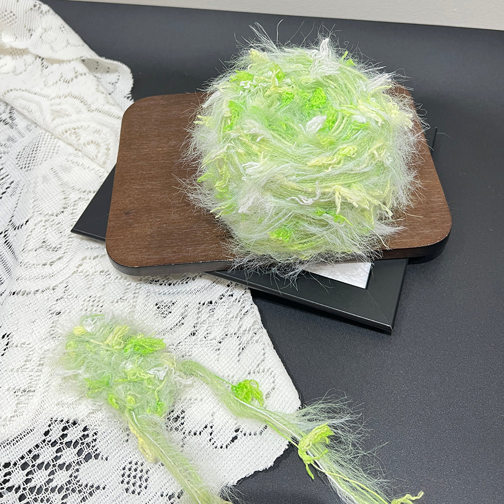 Mint pastel green cake yarn on wooden board with lace decor, muted earth tone handmade fancy yarn