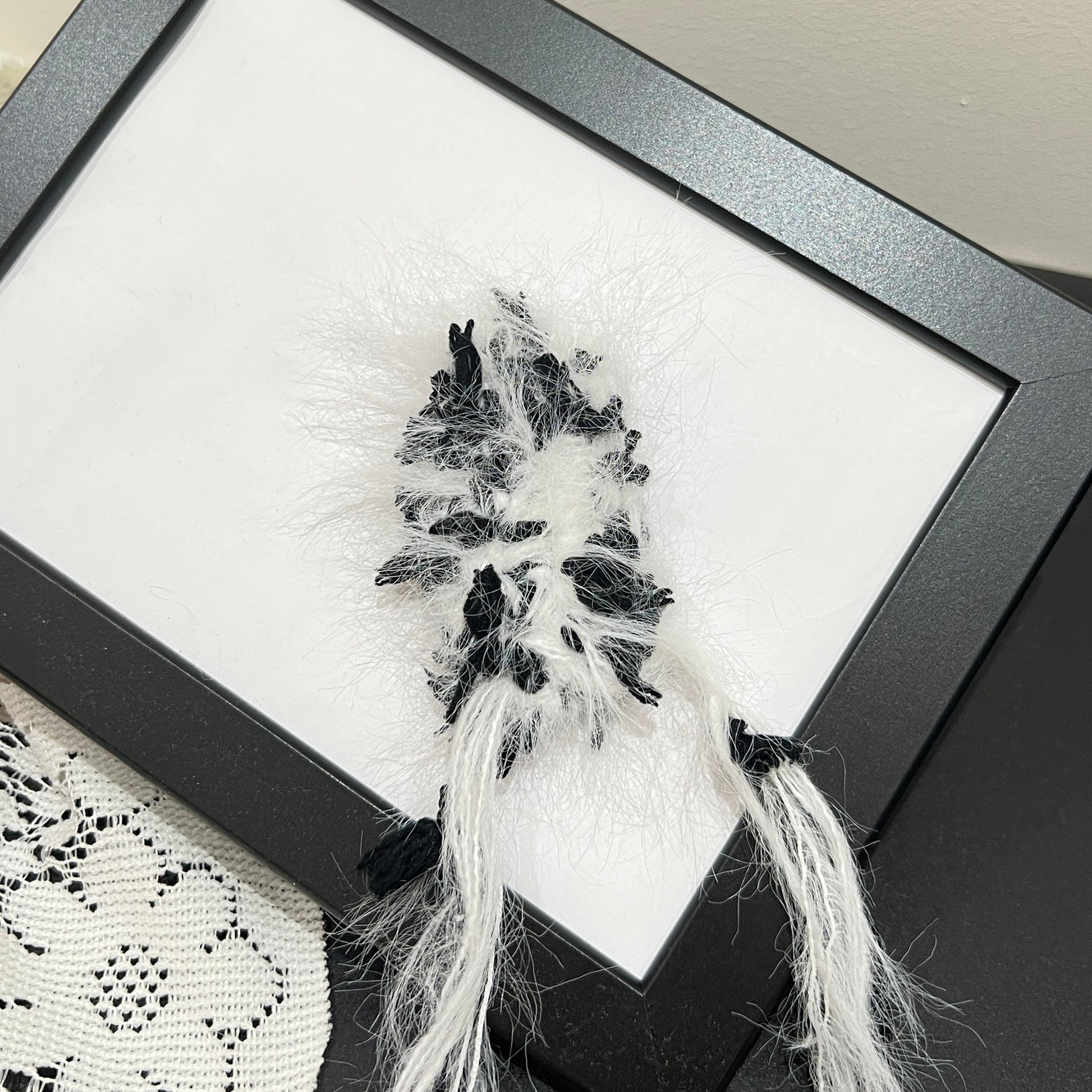 Center overhead view monochrome multi-tone floral hand-blended cake yarn showing layered fiber texture