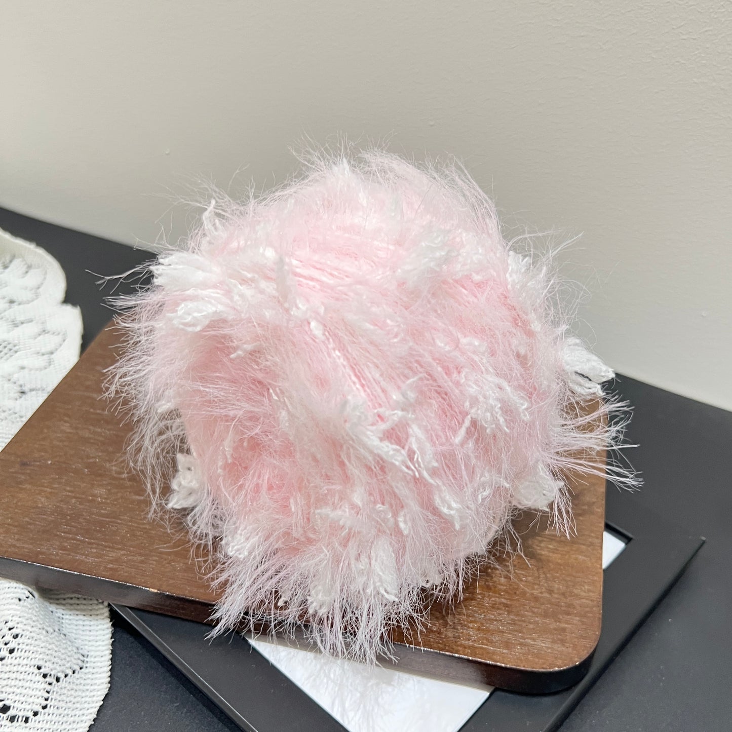 Overhead top view pastel blush layered floral hand-blended cake yarn wound as center-pull ball