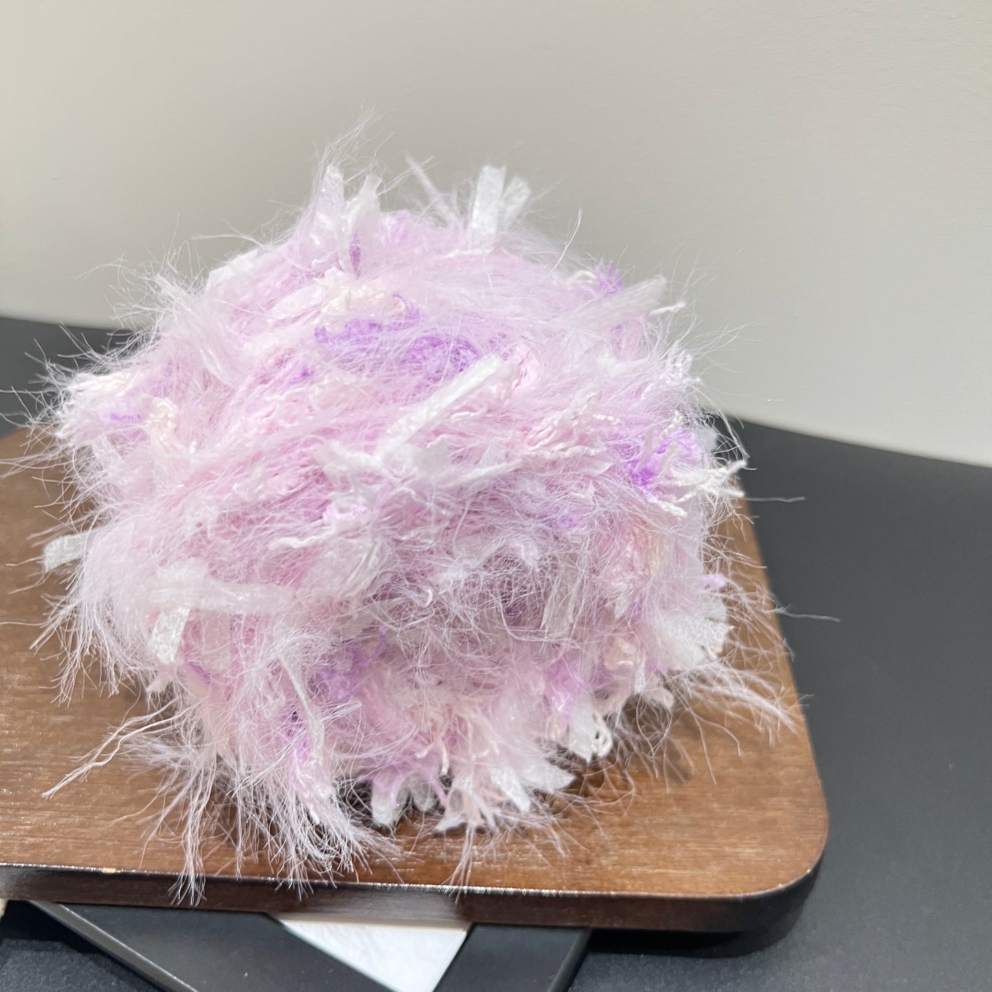 Top overhead spherical shot pastel lavender floral hand-blended cake yarn showing layered airy texture