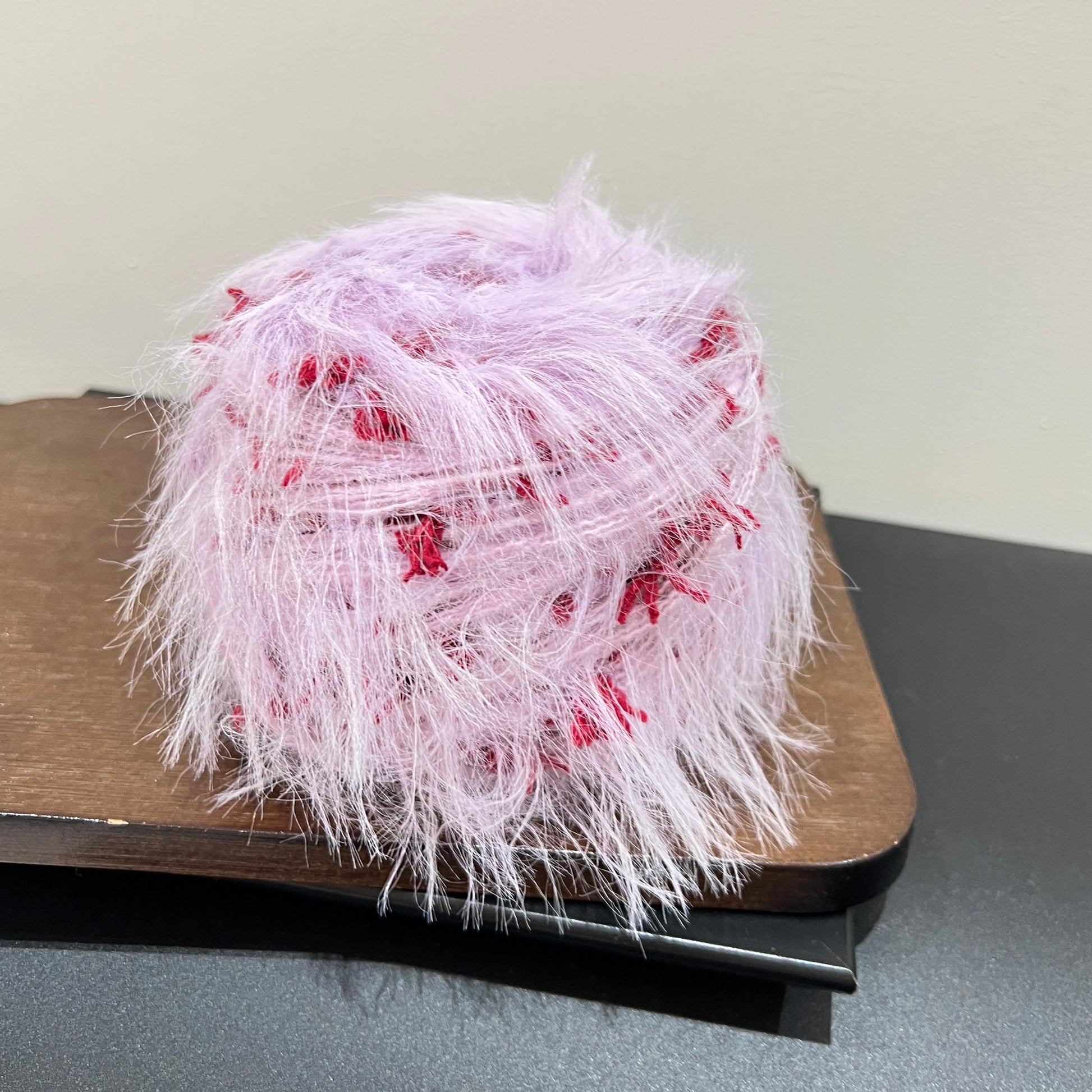 Front overhead round view pastel lilac layered floral hand-blended cake yarn on wooden tray