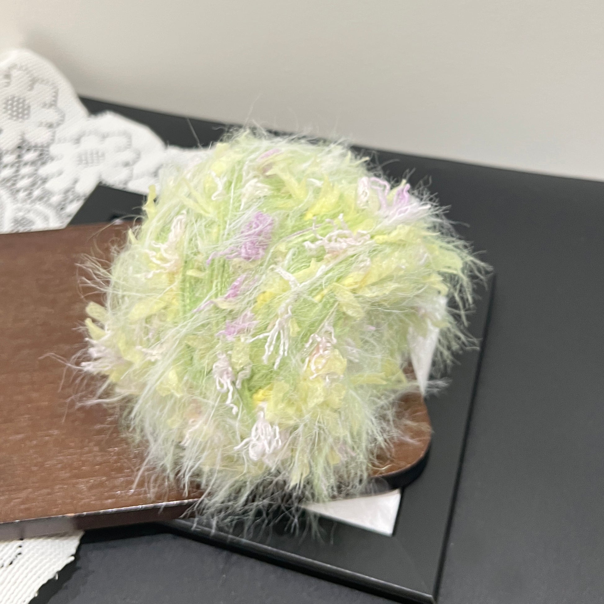 Complete set display of lime yellow lilac yarn cake and fiber swatch on dark flat surface