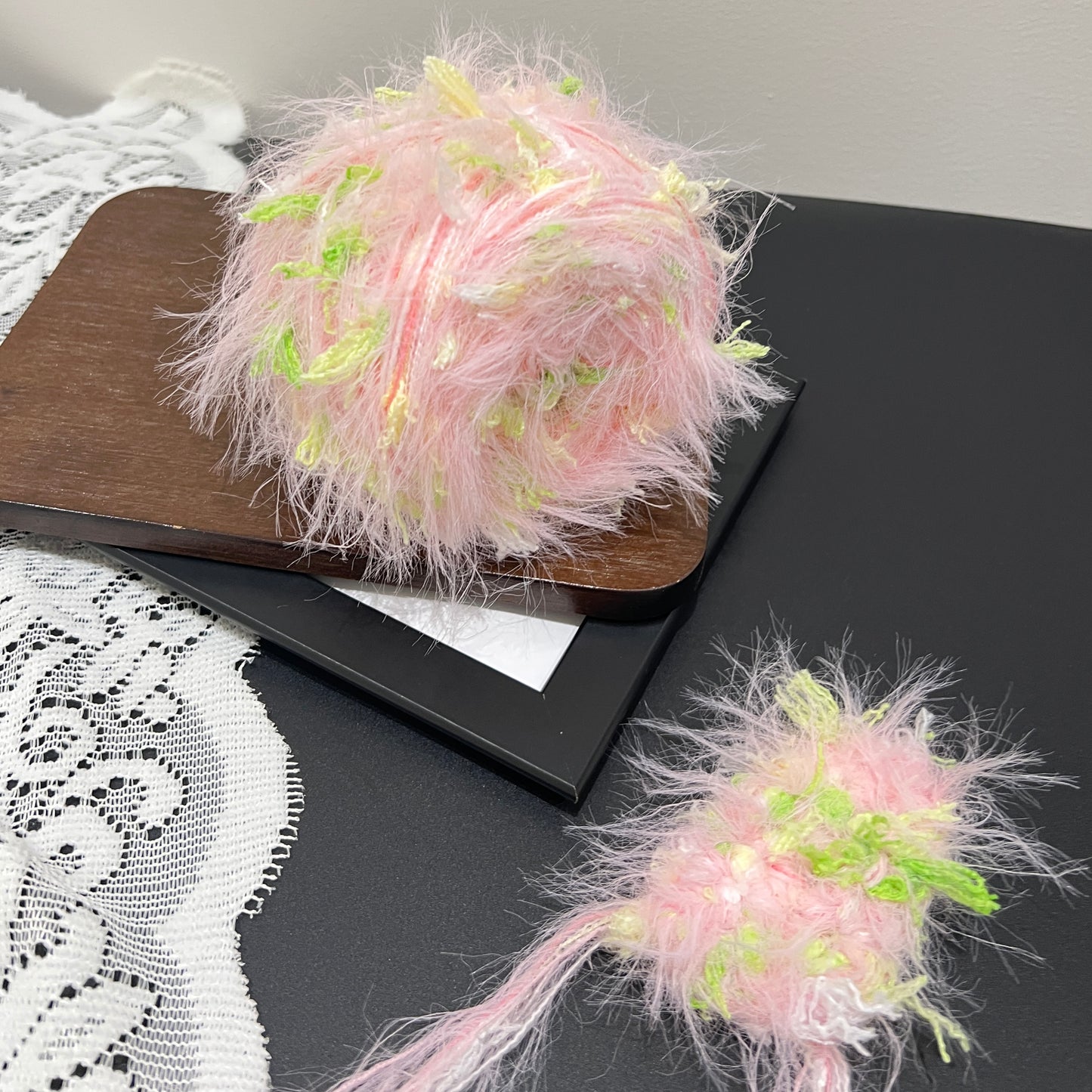 Front overhead round view pastel pink lime layered floral hand-blended cake yarn on wooden tray