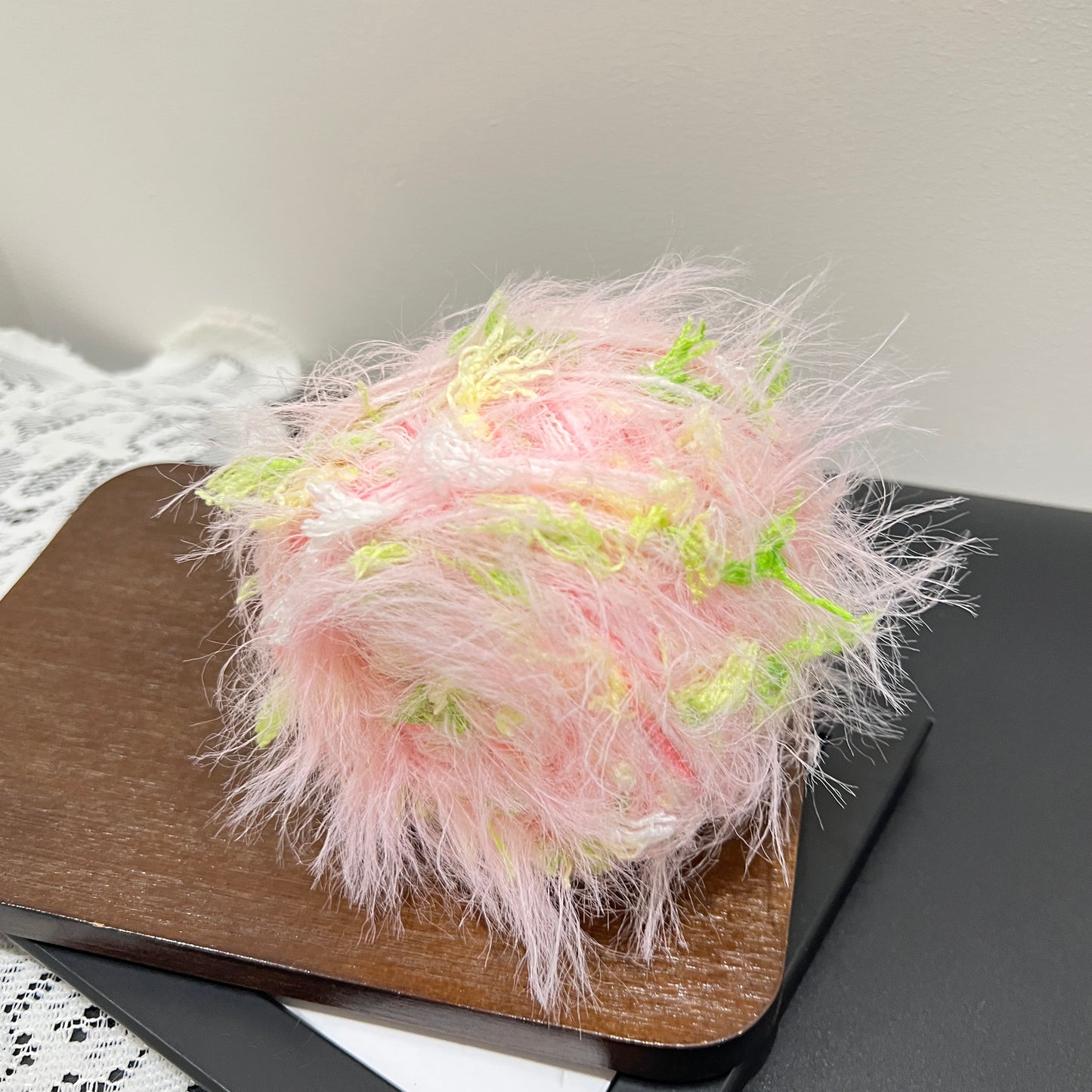 Top overhead view pastel pink lime floral hand-blended cake yarn with layered fiber texture