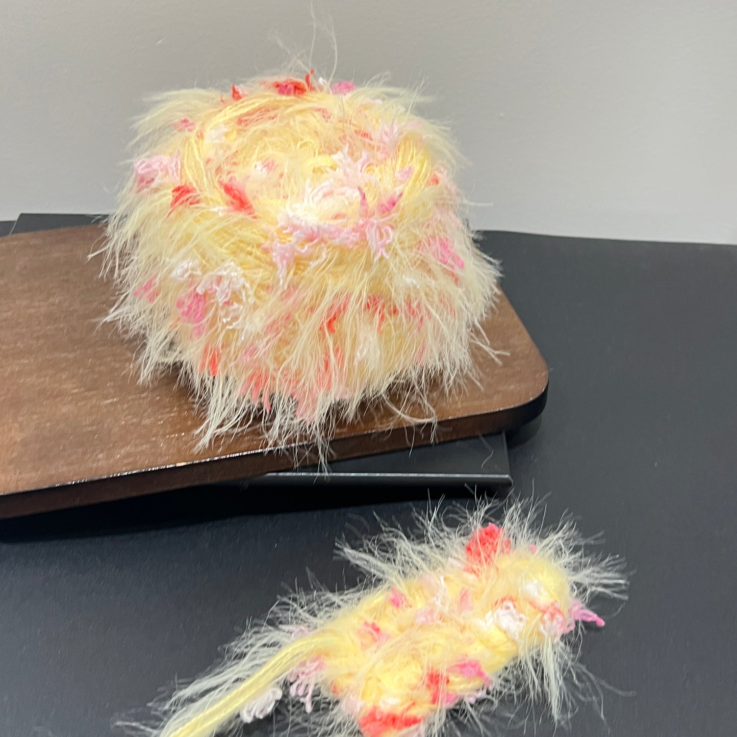 Layout shot of yellow blush red yarn cake and matching fiber swatch beside hollow white lace fabric