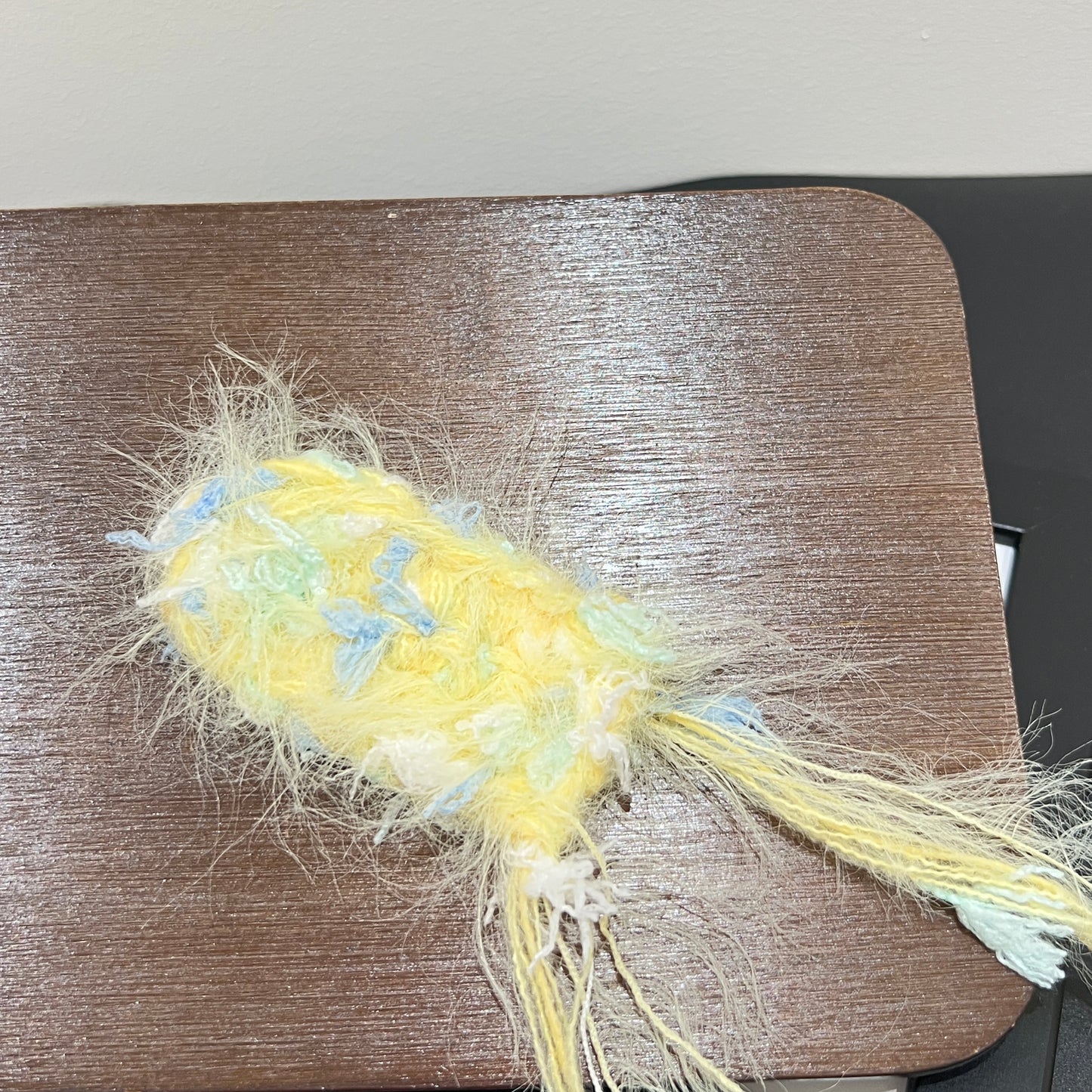 Close-up macro detail of pastel yellow sky mint petal layered multi-strand blended fiber mounted on wooden display board