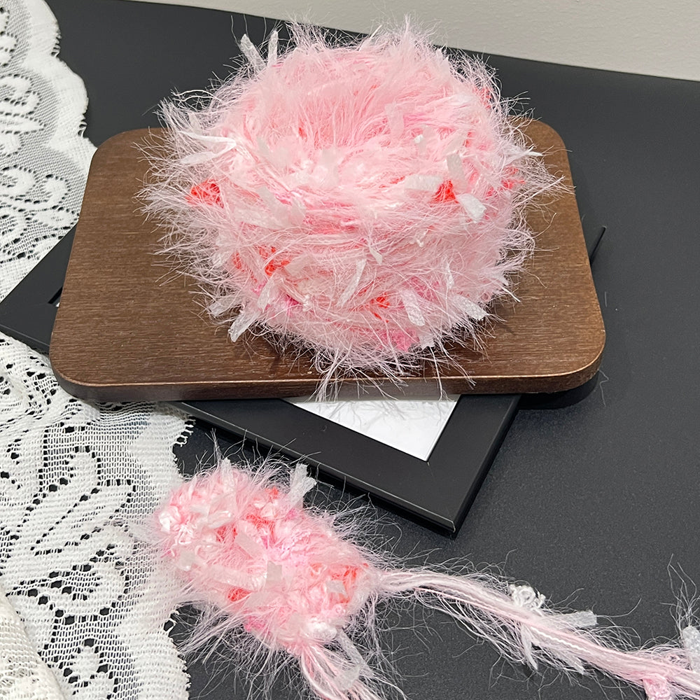 Romantic peach pink floral cake yarn on dark table with lace, feminine pastel multi-tone art yarn