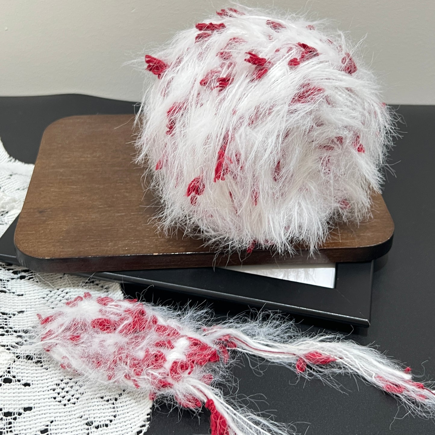 Top overhead full spherical shot white crimson floral hand-blended yarn ball showing airy fuzzy layered texture